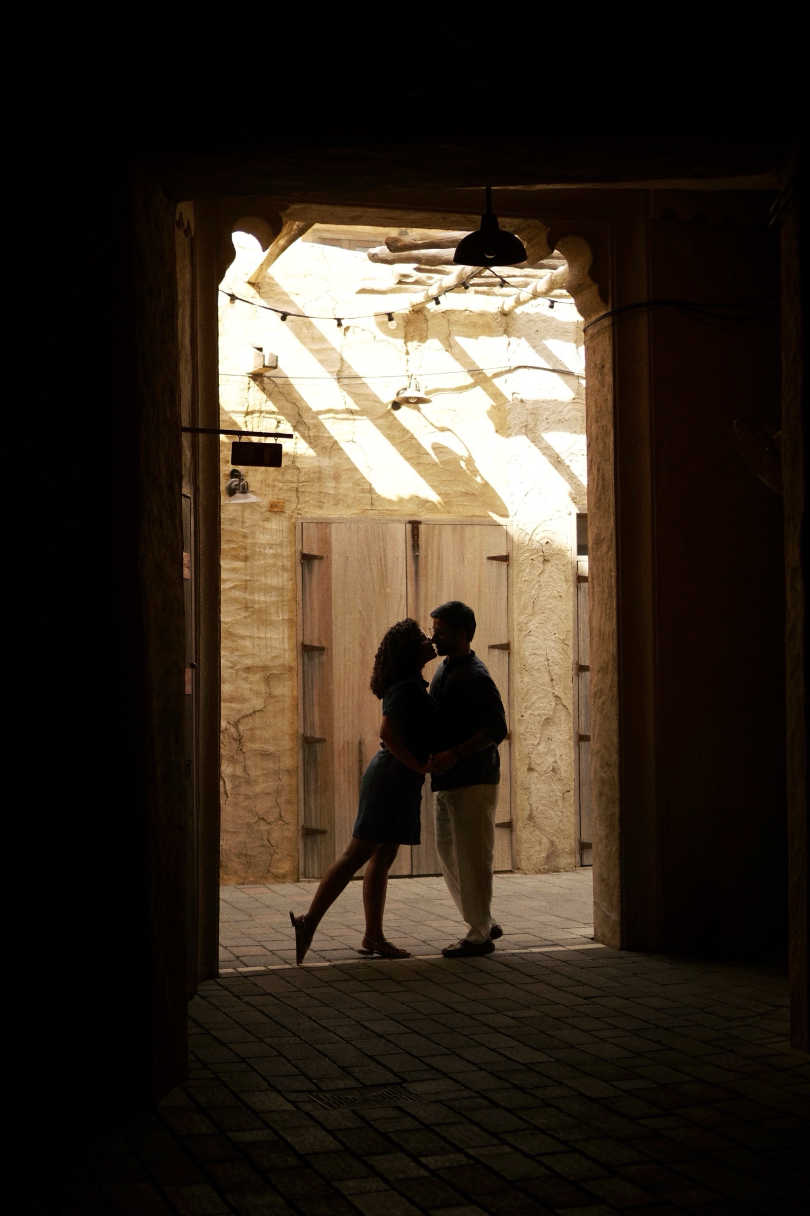 Couple silhouette sharing a kiss in a doorway