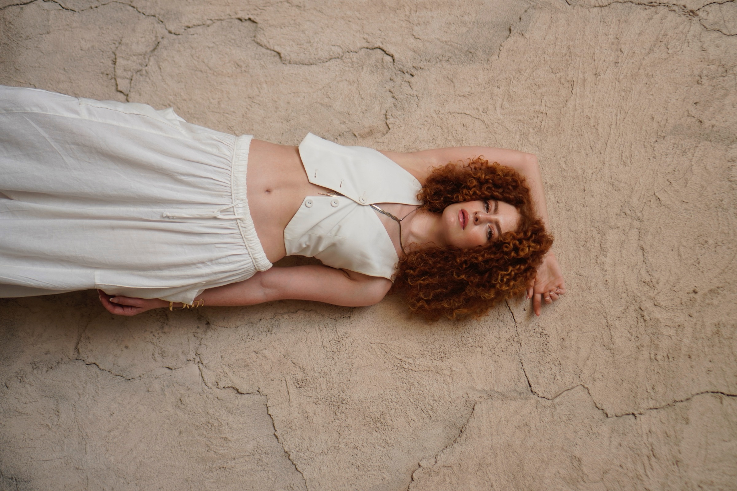 Woman in white lying down, editorial portrait