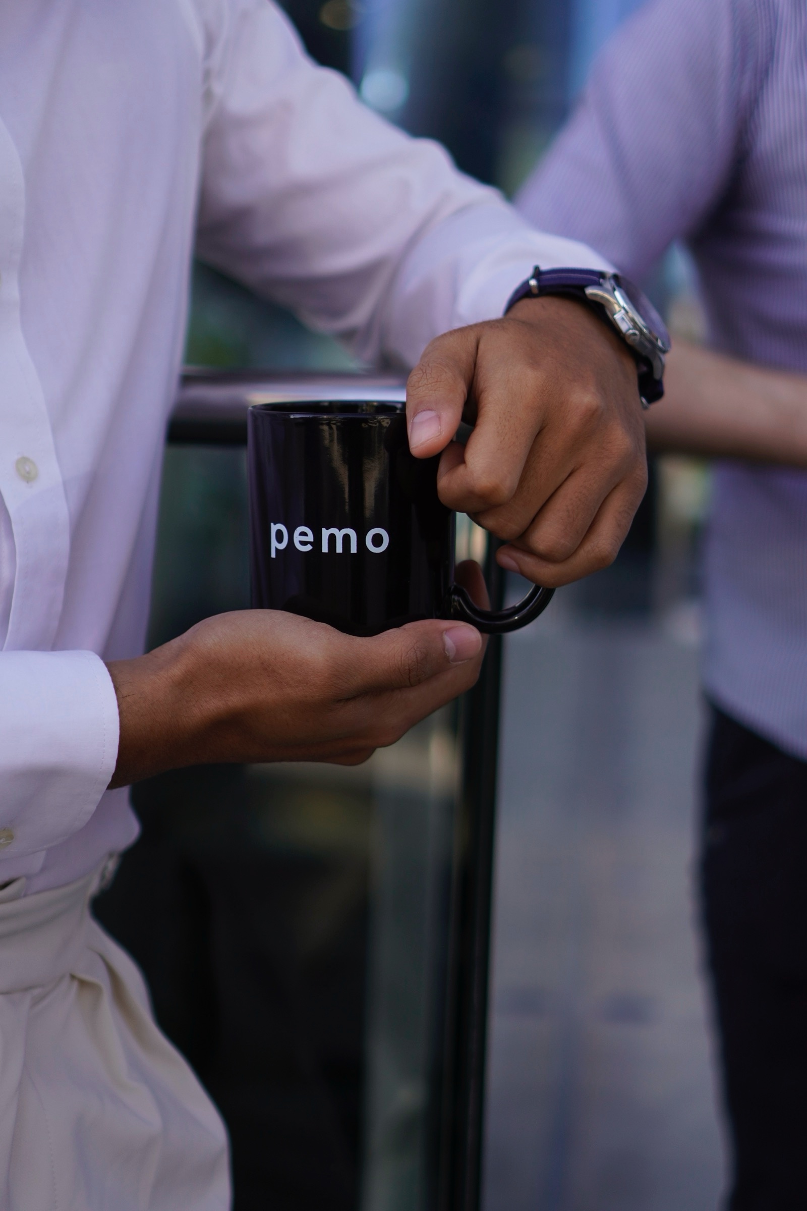 Hand holding a branded coffee mug in the office