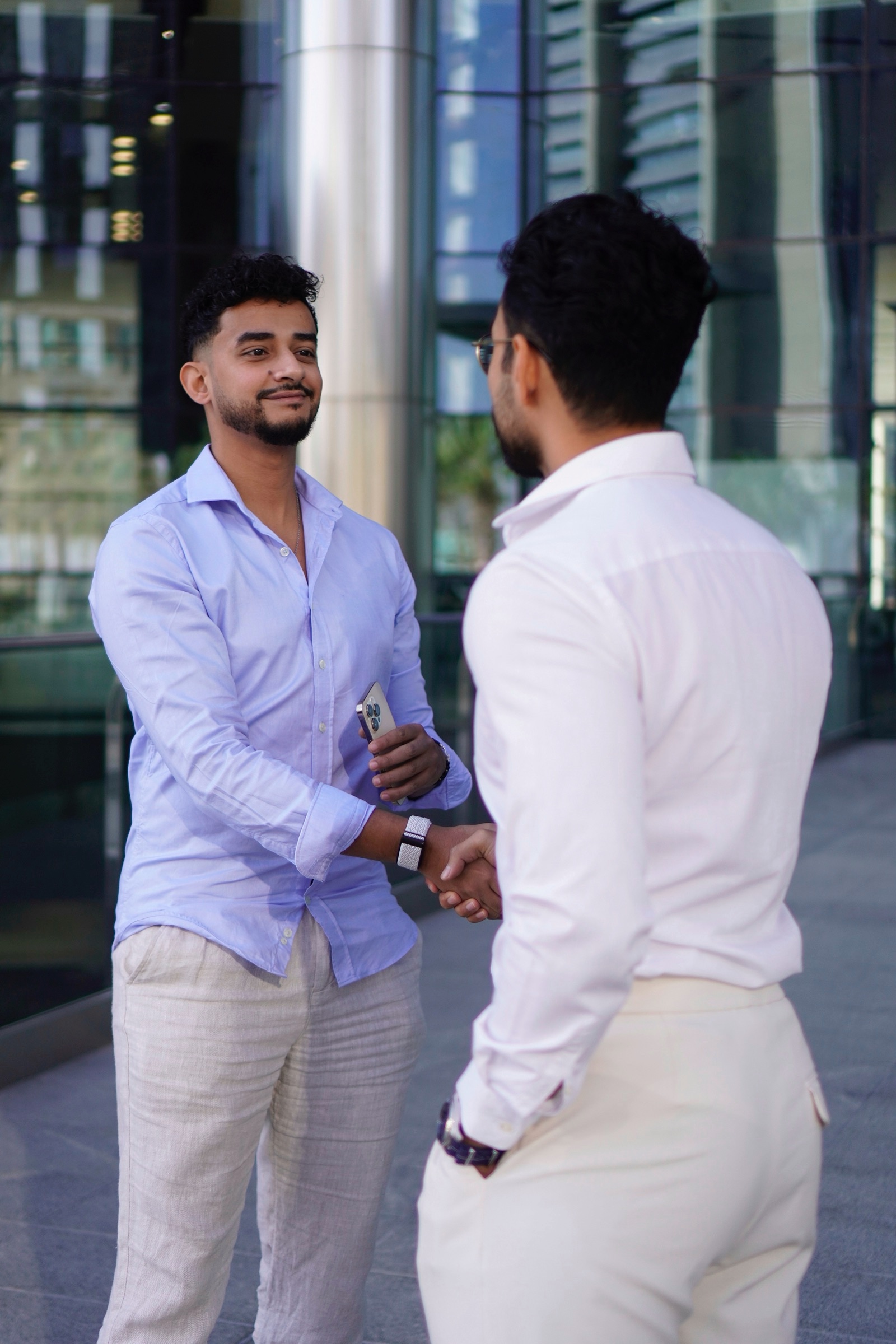 Two men shaking hands outside the office