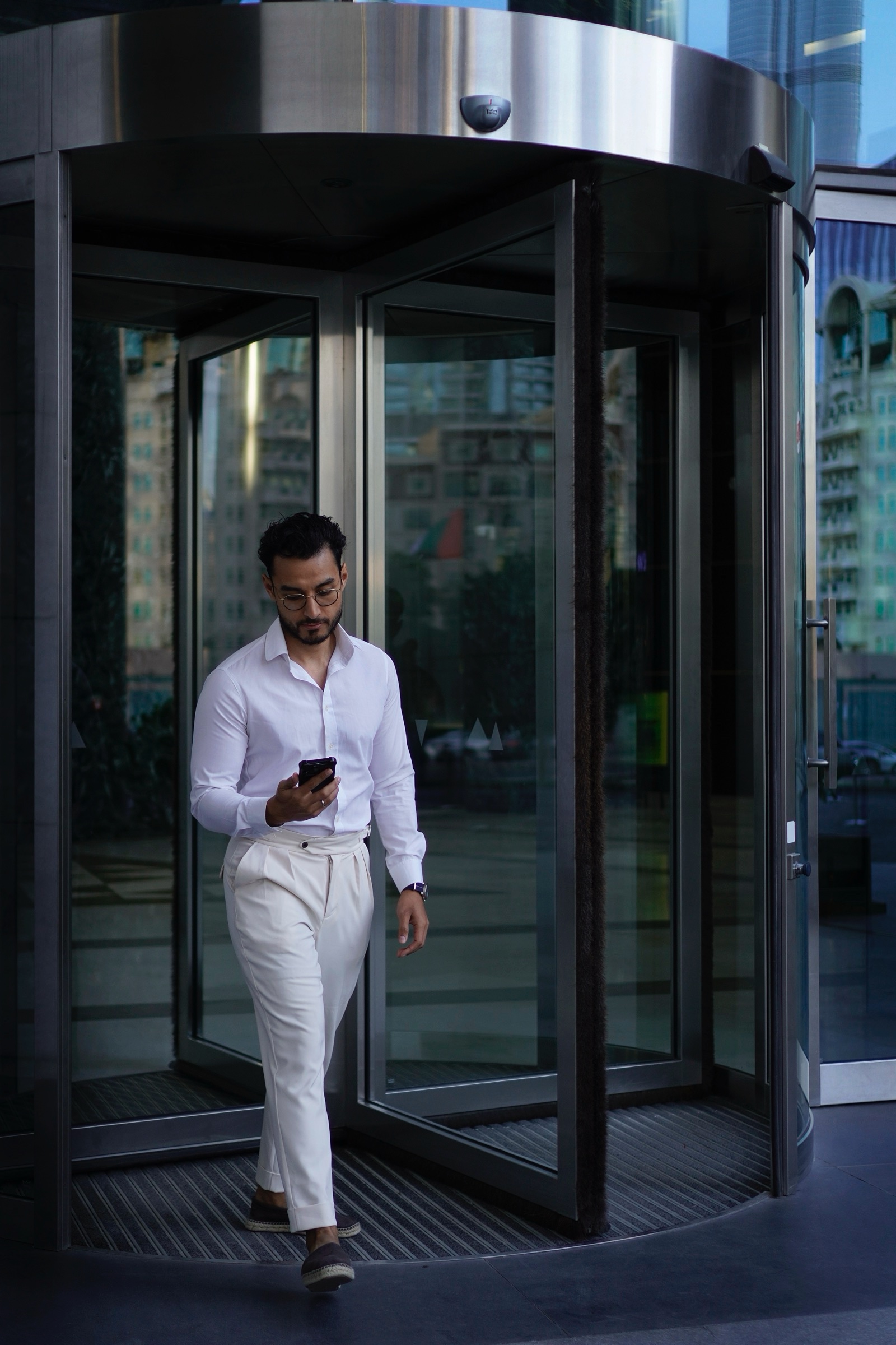 Businessman on his phone at a revolving door