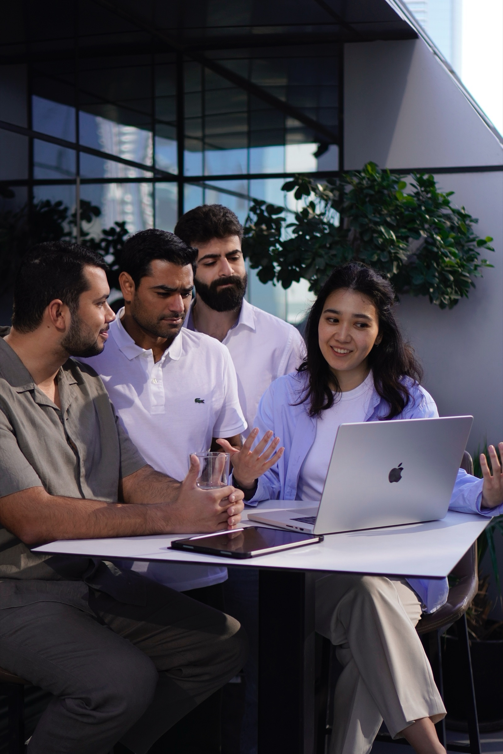 Colleagues gathered around a laptop in a meeting