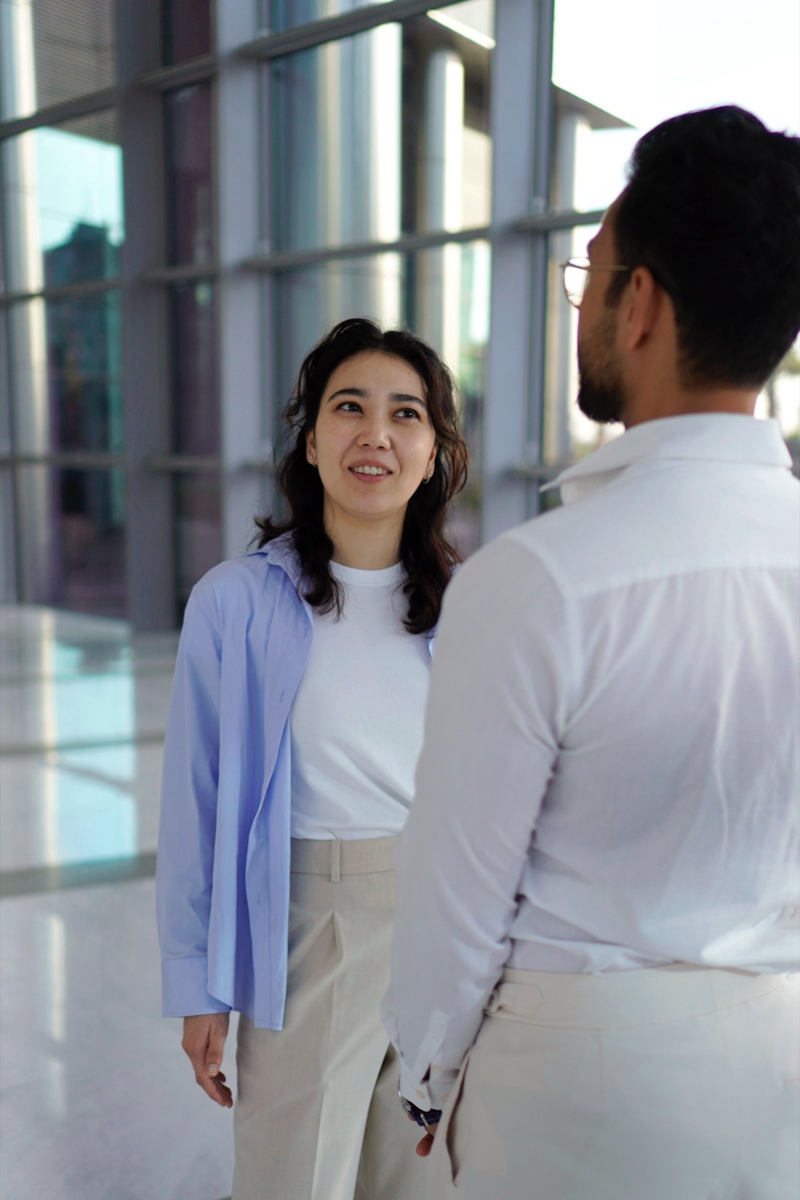 Two colleagues talking in a glass office