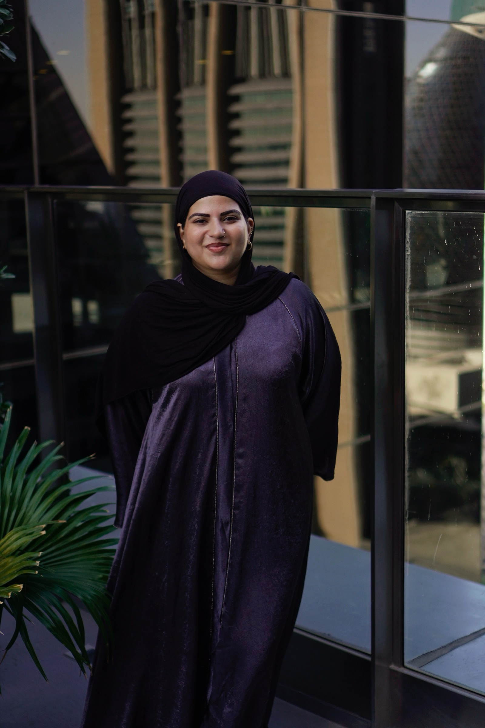 Businesswoman in an abaya by the office window