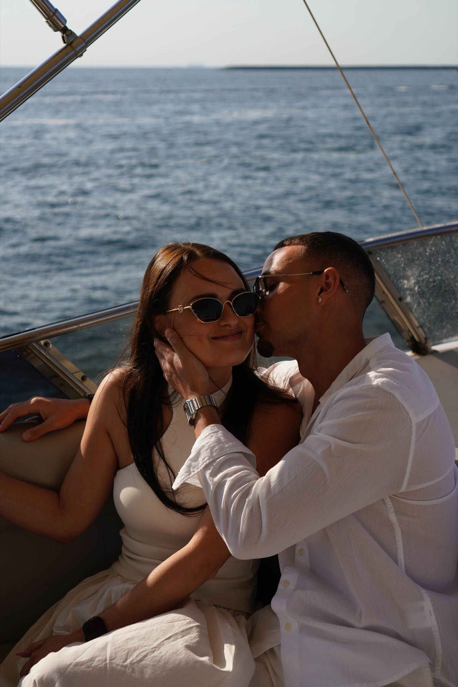 Couple in white, a kiss on the cheek on the yacht
