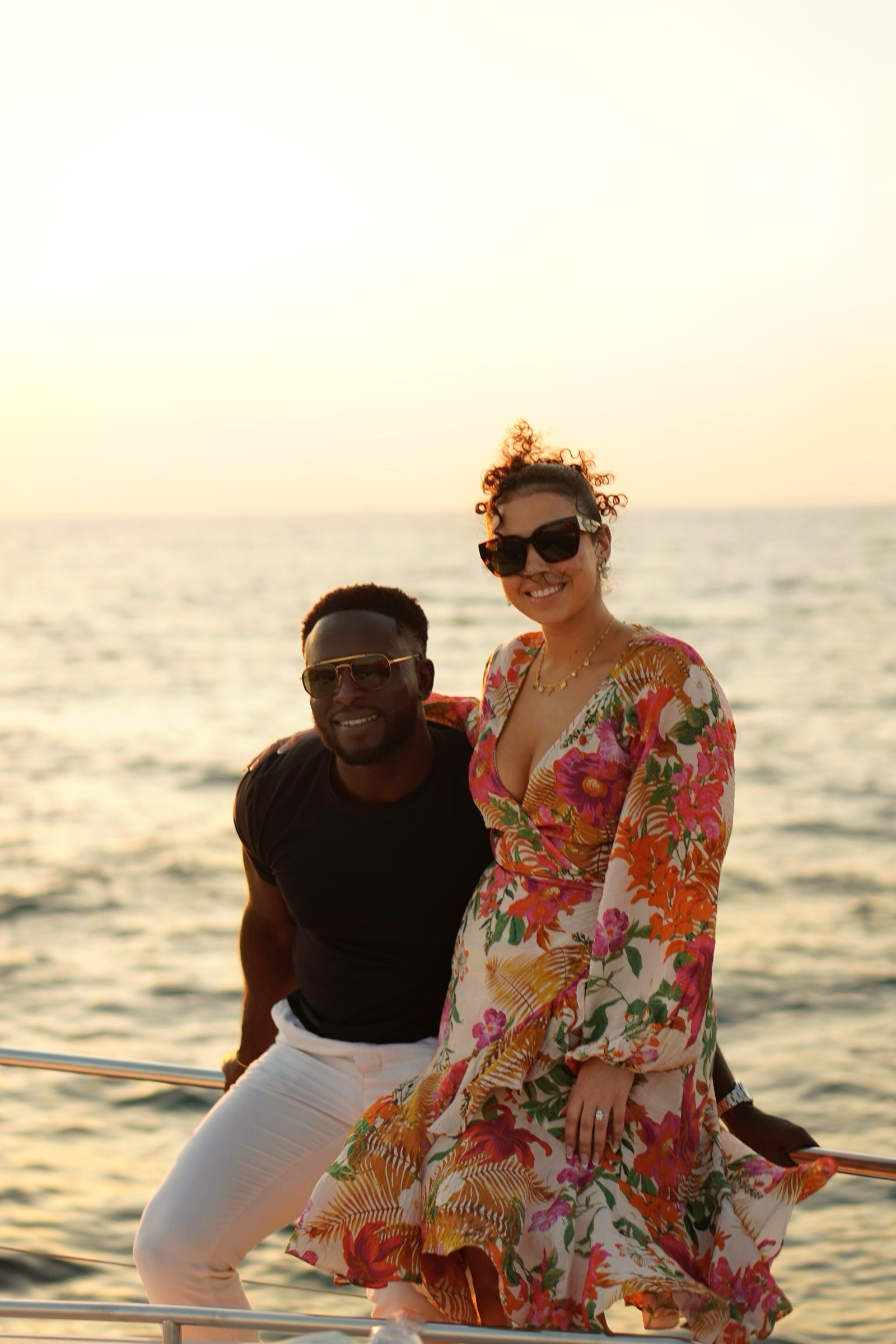 Woman in a floral dress seated at sunset on a yacht