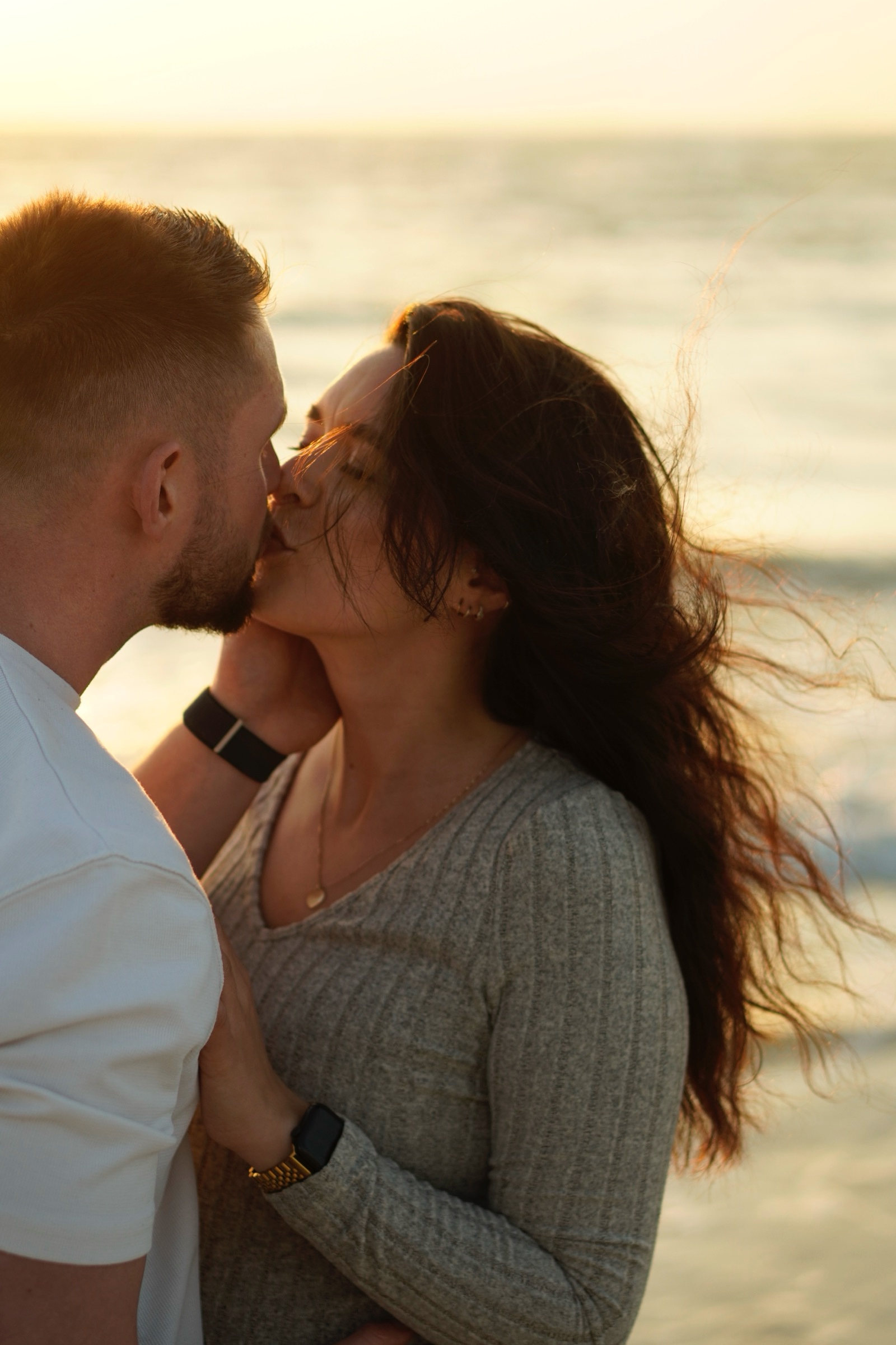 Couple kissing on the beach at sunset