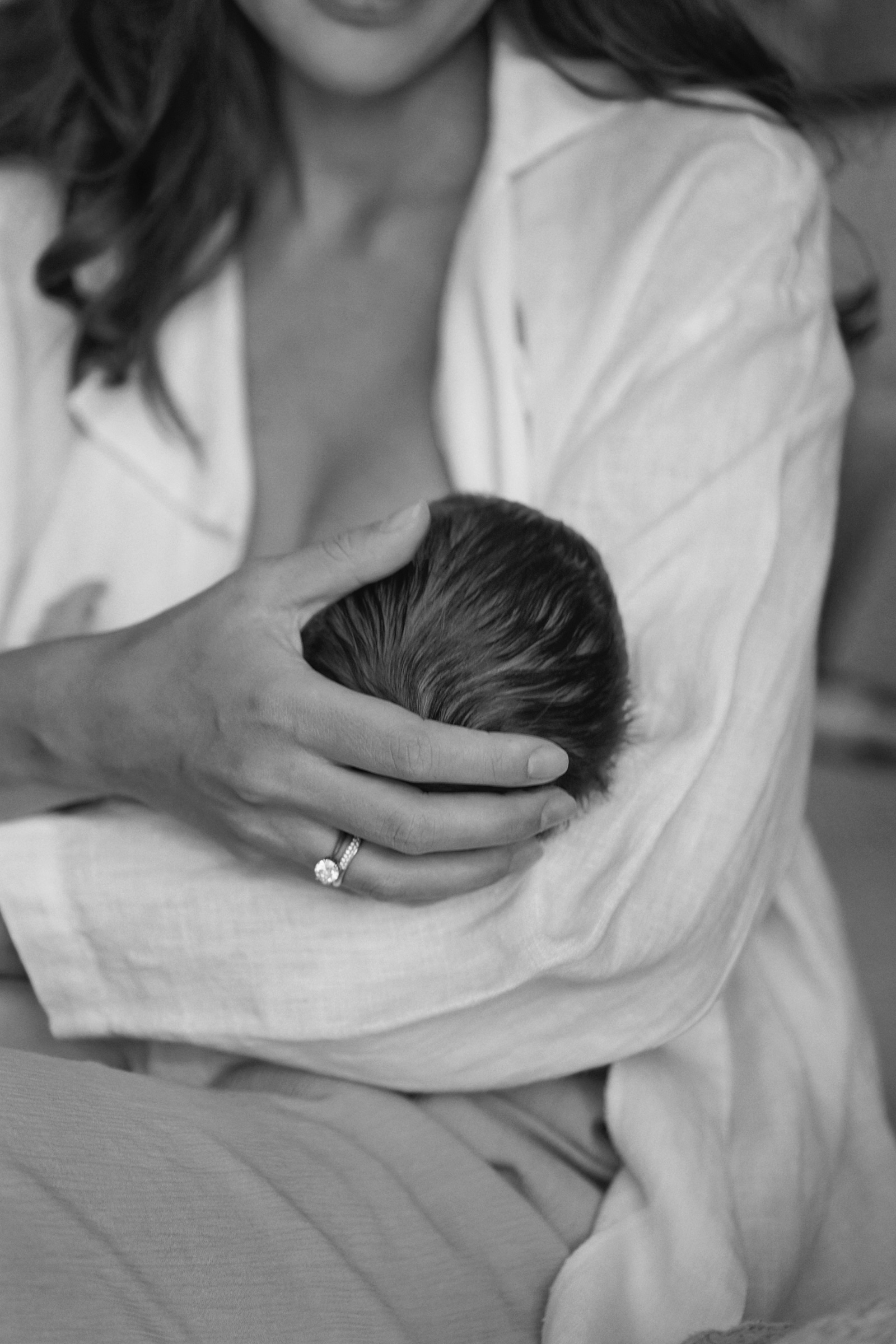 Mother in white cradling her newborn