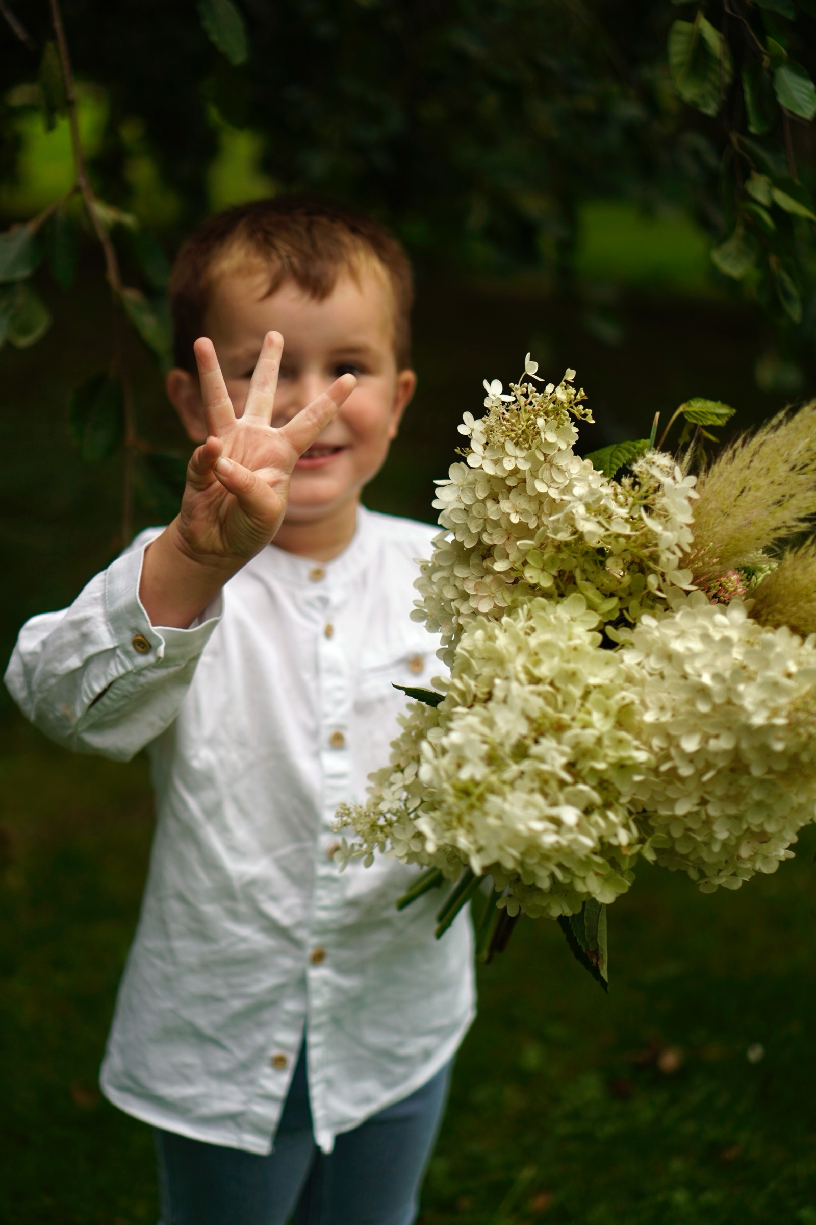 Young boy holding a white hydrangea bouquet