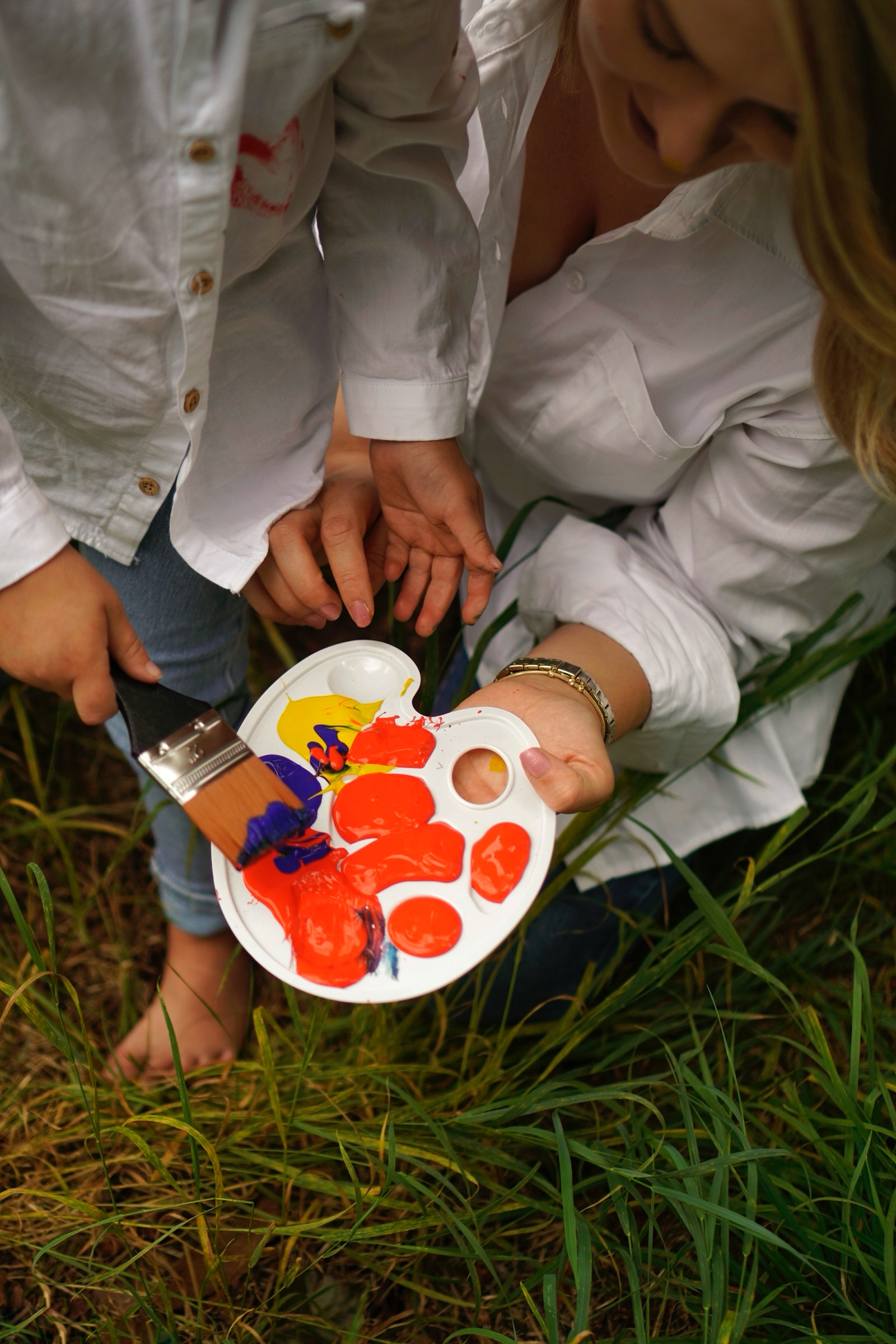 Paint palette and bare feet on the grass