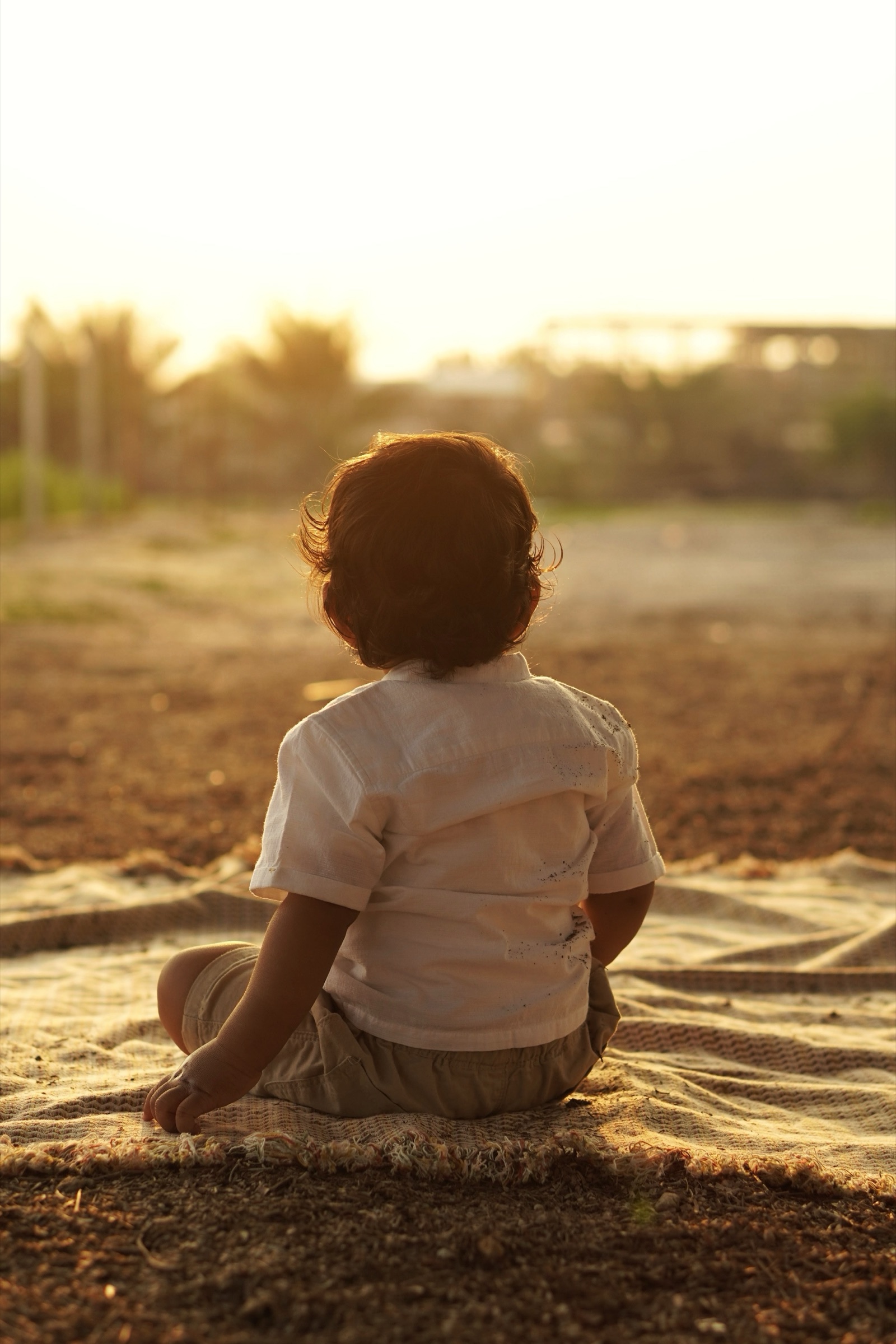 Child silhouetted against the sunset in a field