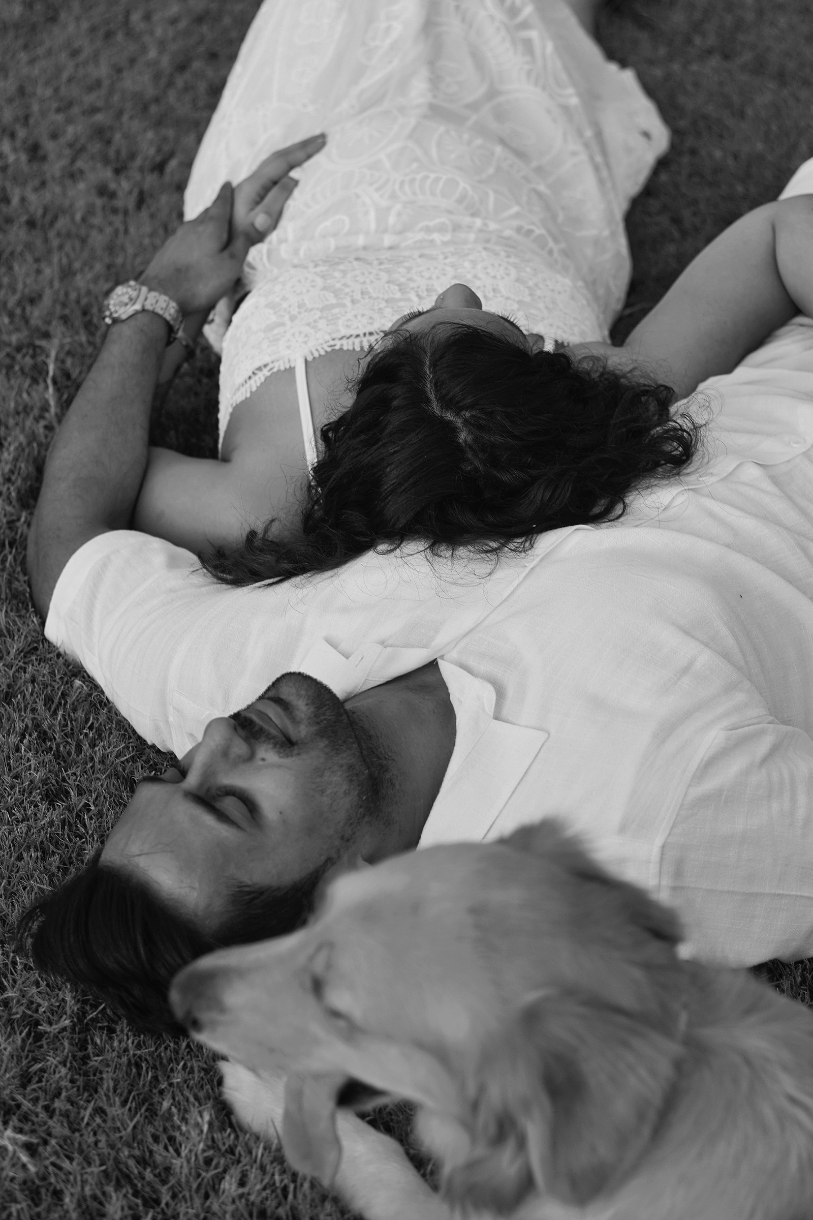 Couple lying together in the grass, black and white