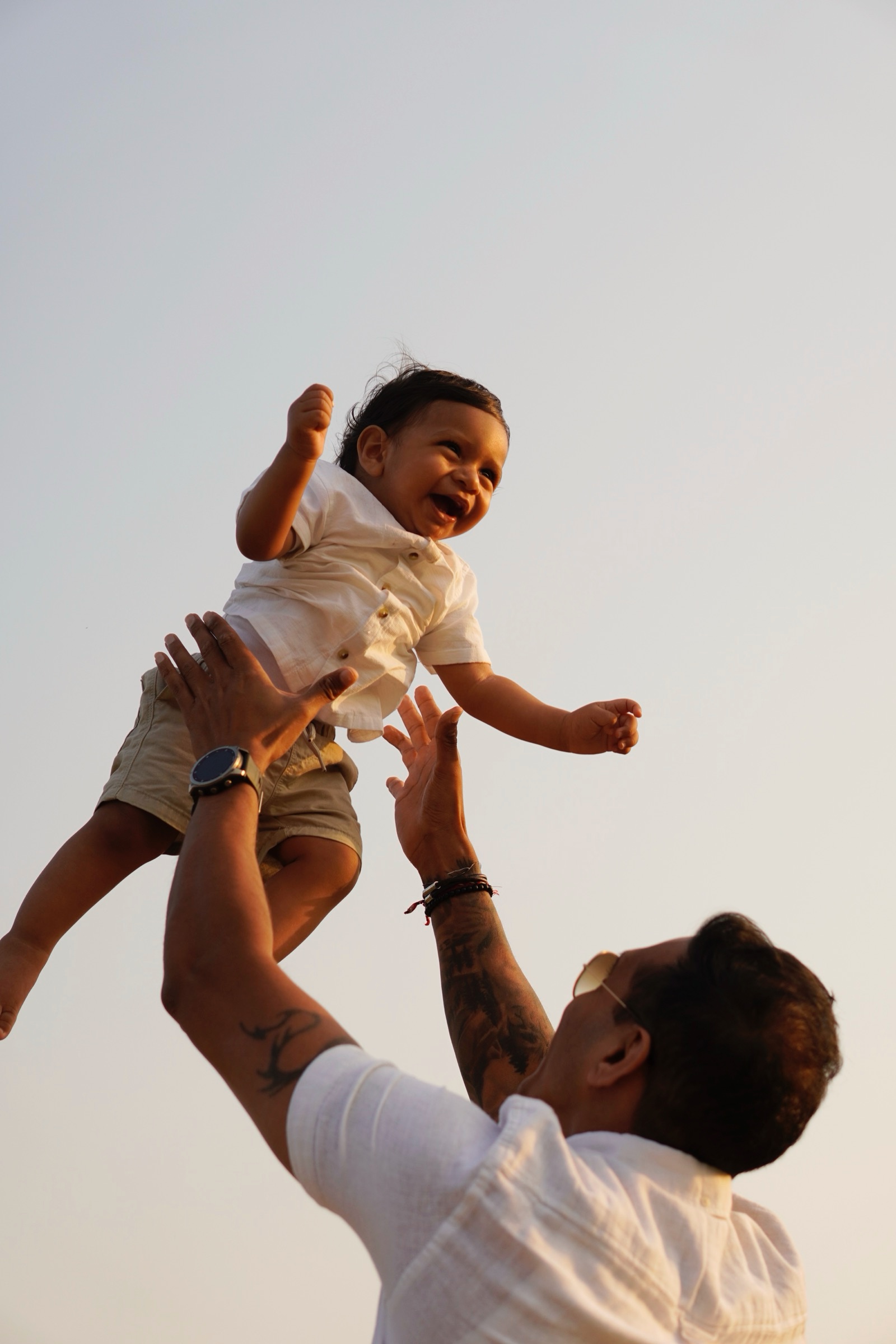 Father tossing his laughing child into the air