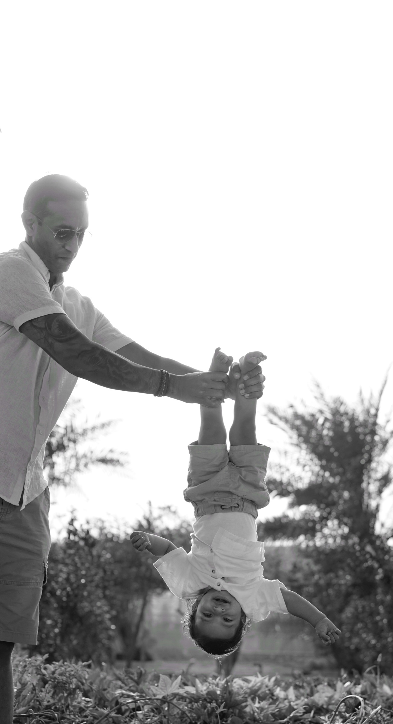 Grandfather lifting a baby in the air, black and white