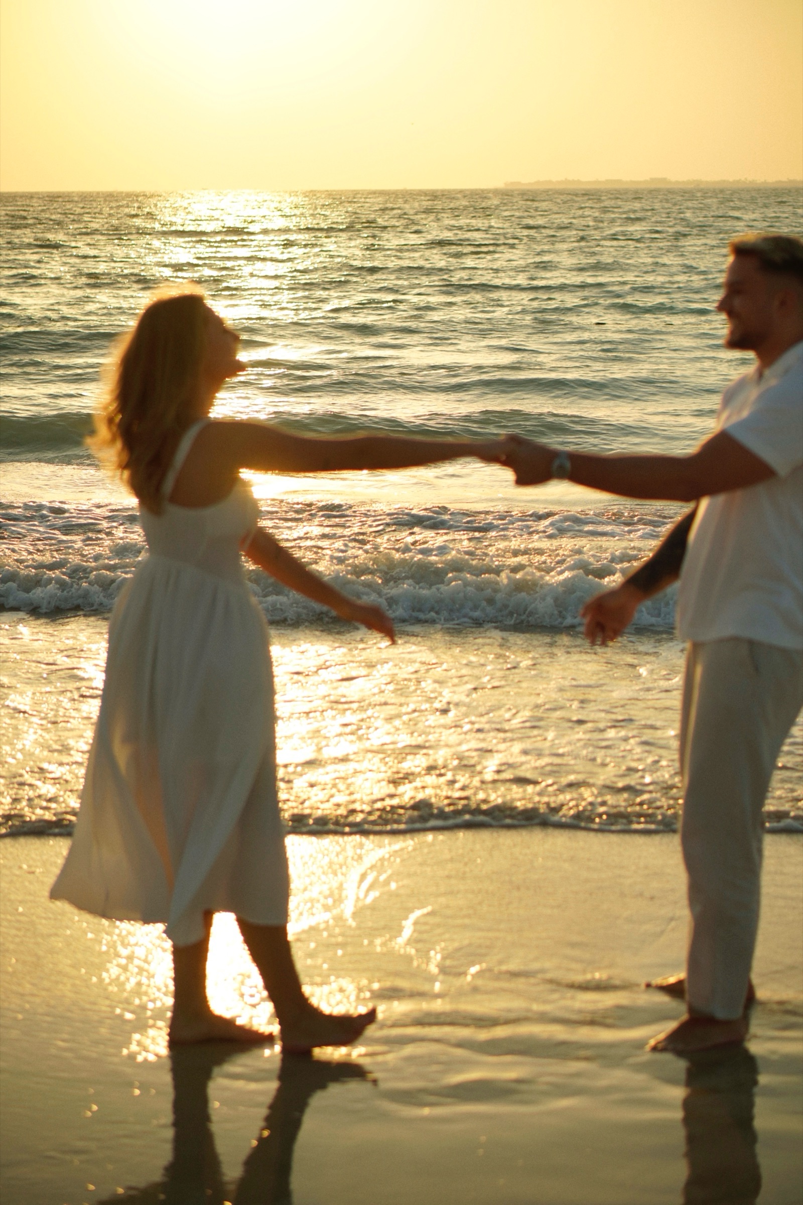Couple dancing holding hands at sunset