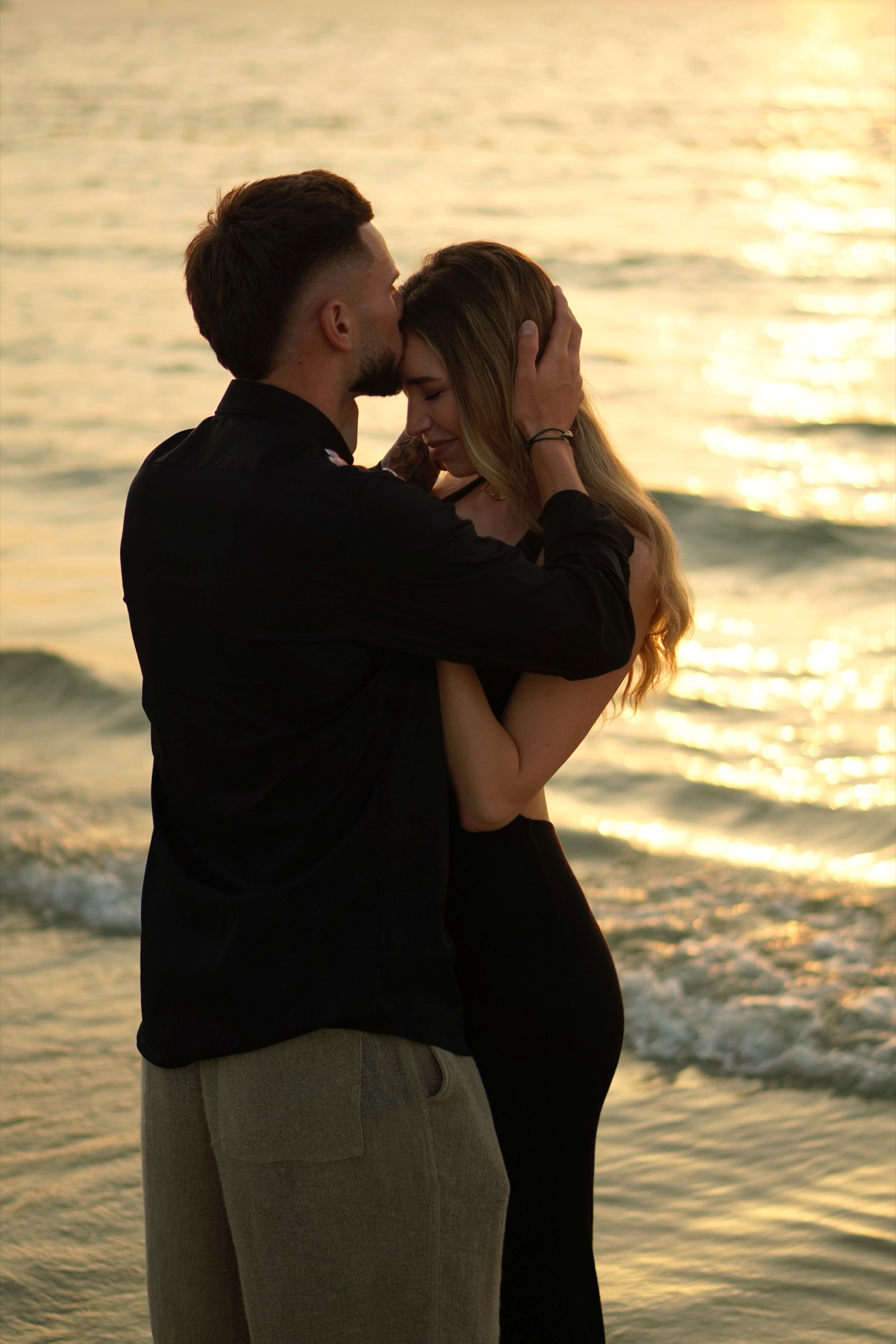 Couple embracing with forehead kiss at beach