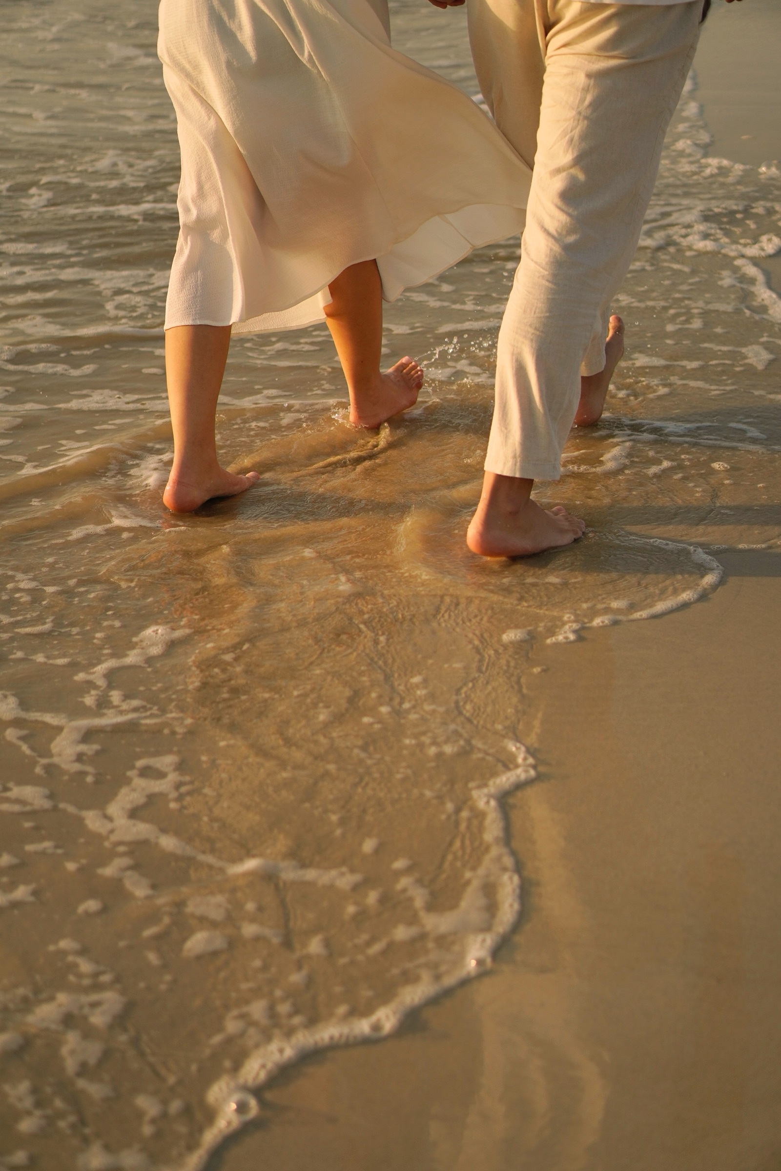 Couple feet walking in waves