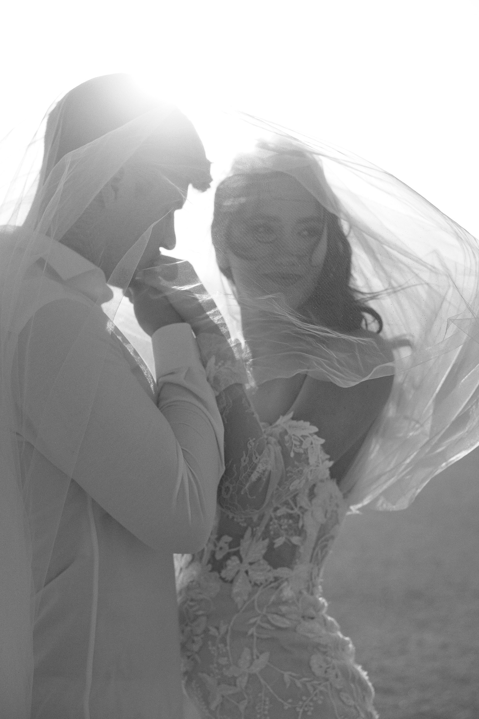 Couple under a veil, foreheads together, black and white
