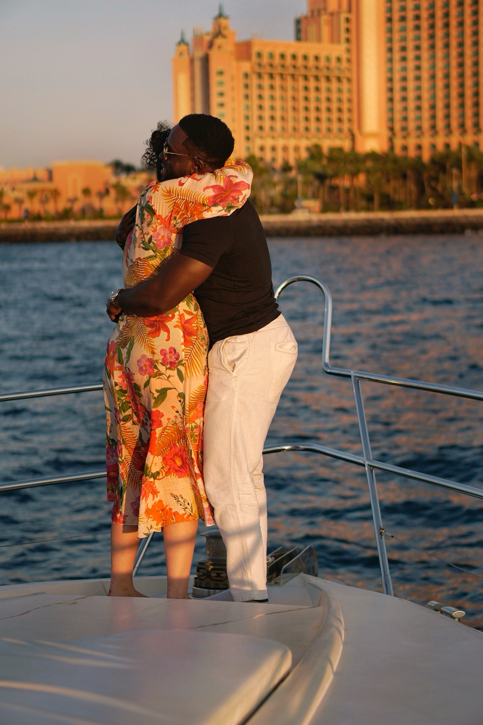 Couple embracing on yacht, Atlantis behind