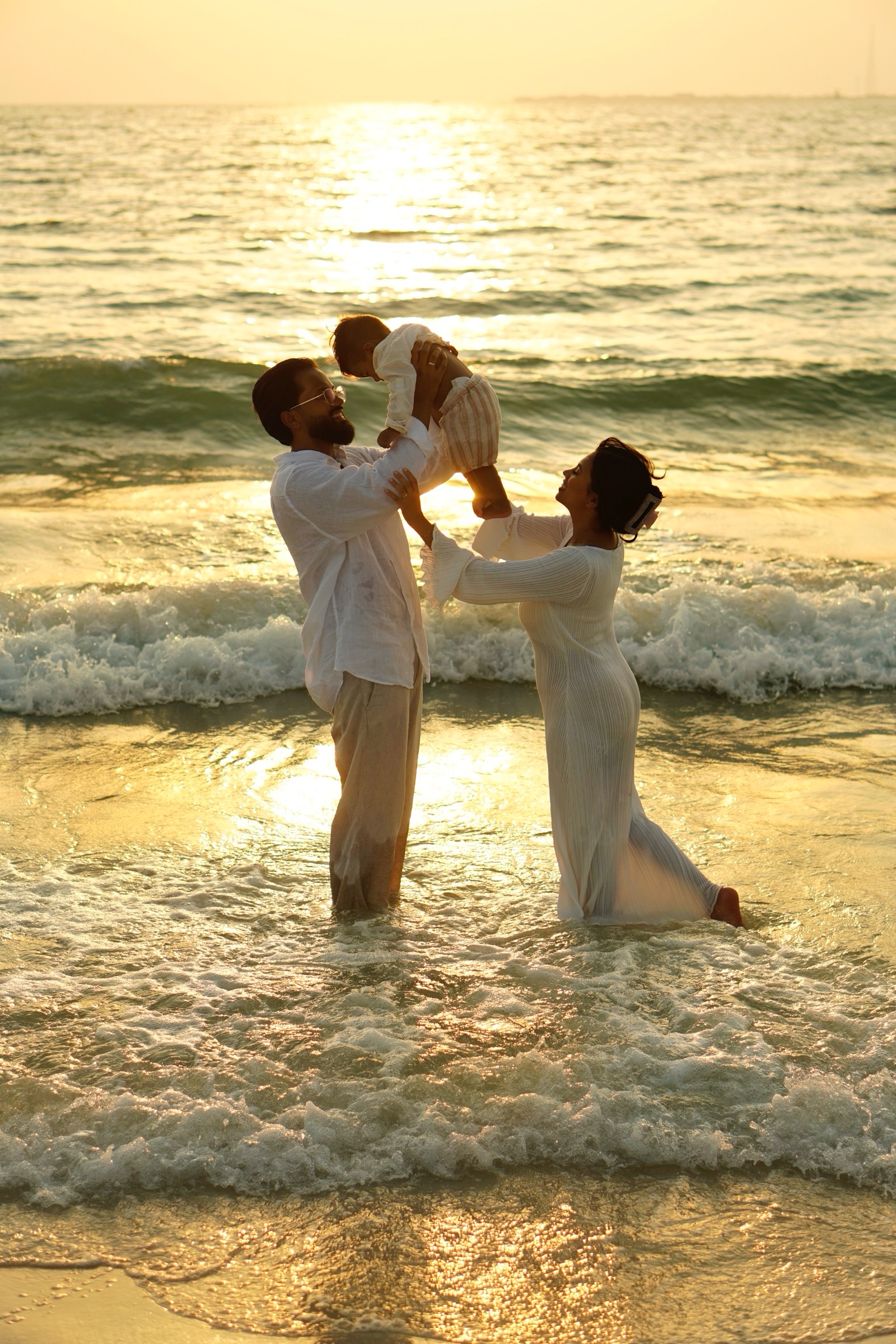 Family lifting their child in the sea