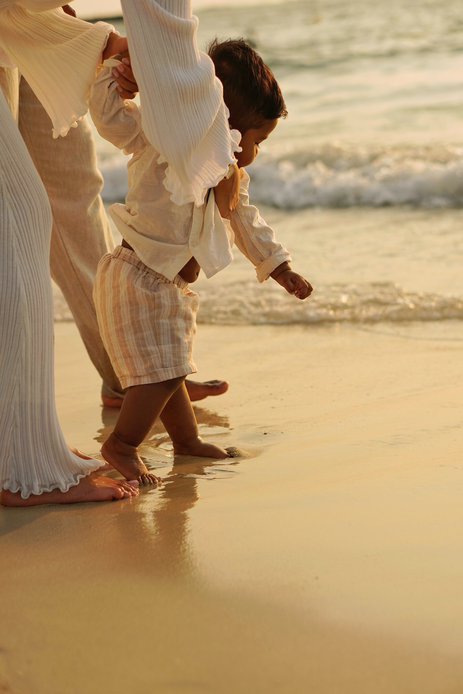Family walking the shore with their child